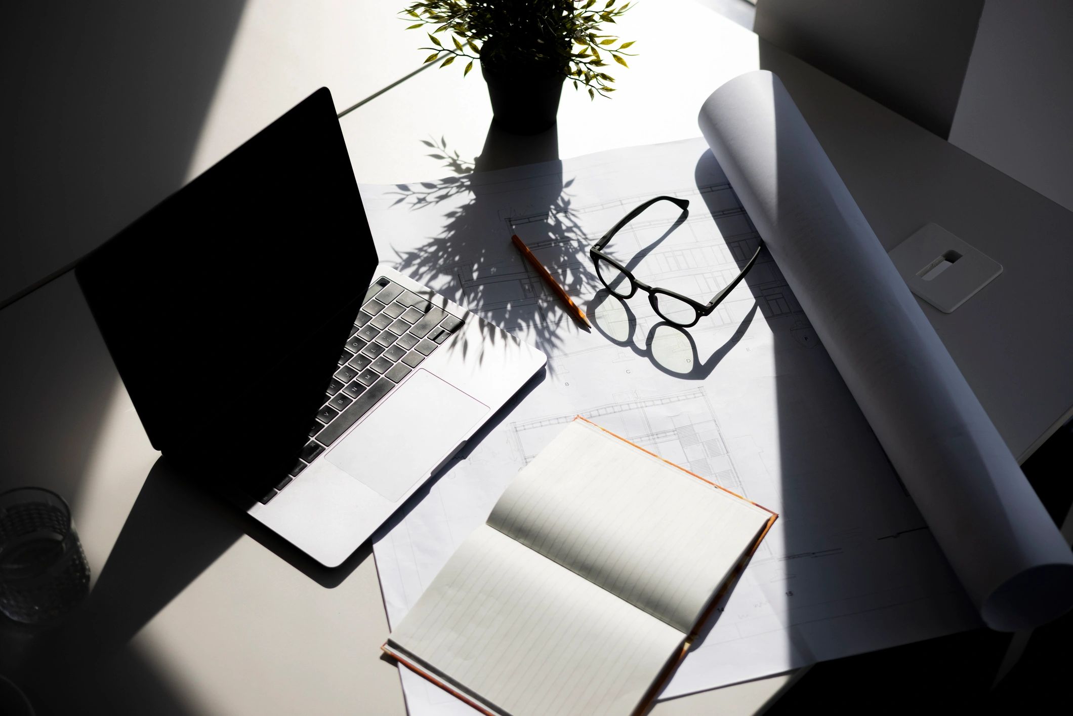 Architectural blueprint and laptop on a work desk