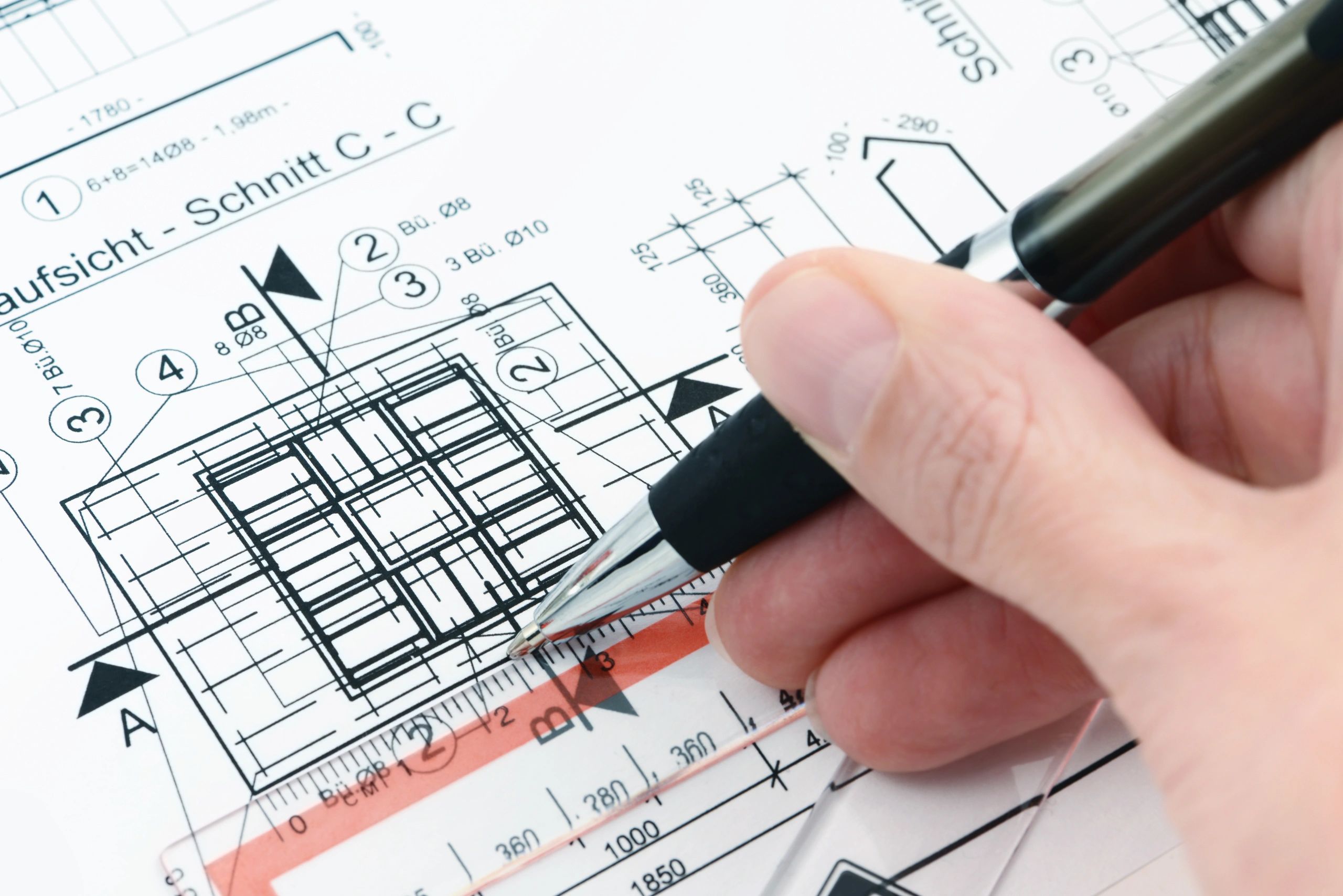 Designer marking up a residential blueprint with drafting tools
